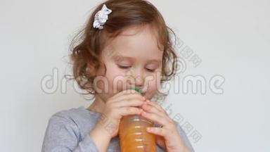 小可爱的女孩从瓶子里喝橘子<strong>饮料</strong>。 婴儿和新鲜果汁，冰沙，柠檬水，新鲜